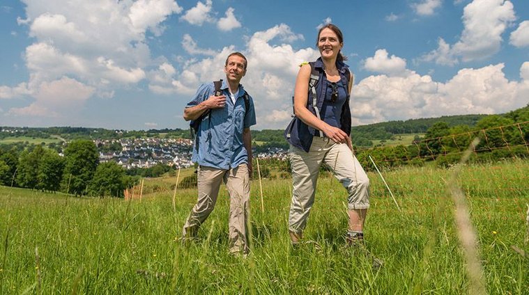 Paar beim Wandern in einer schönen Landschaft mit Wolken