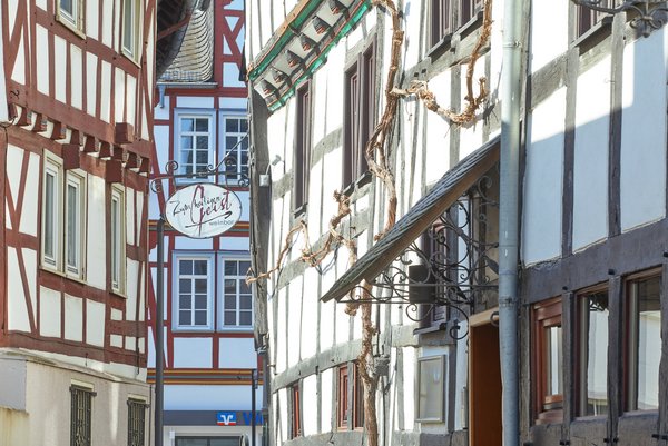 Blick auf Fachwerkhäuser und ein Geschäftsschild in einer Altstadt